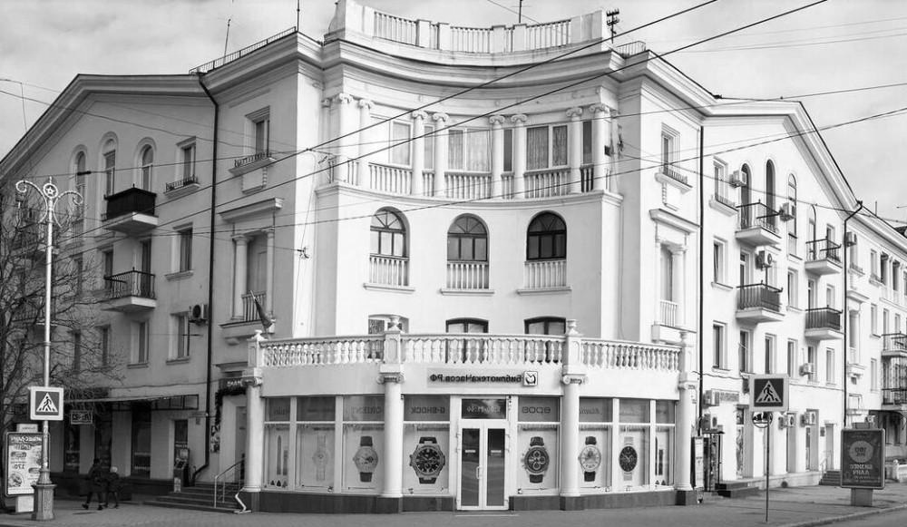 Типичный сталинский дом с высокими окнами, лепниной и характерным архитектурным декором в центре Севастополя