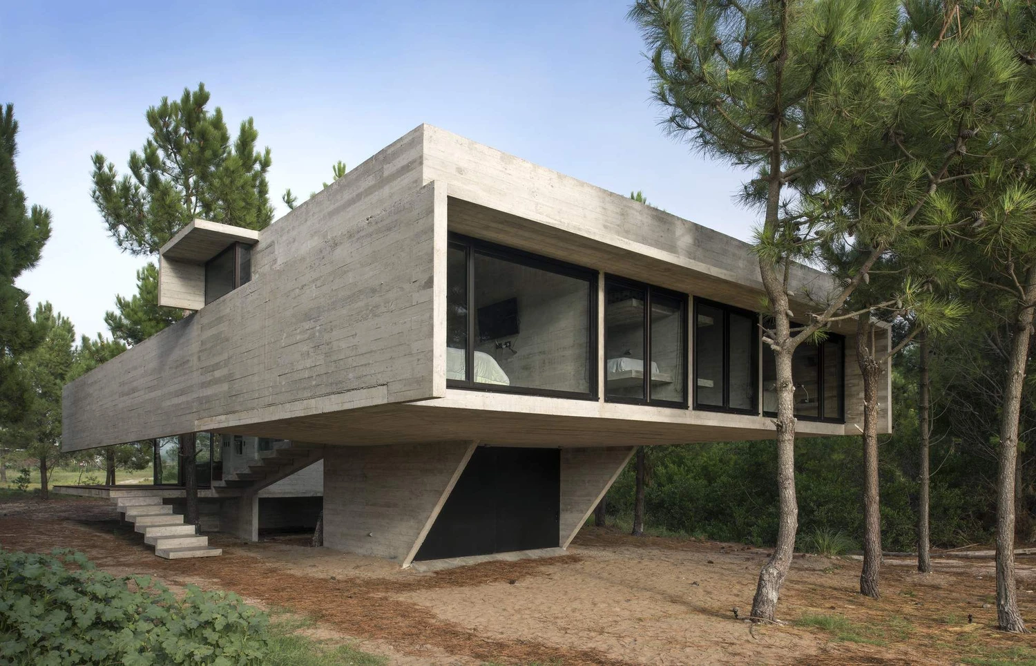 Построенный частный дом по монолитной технологии: гладкие стены, остекление, виден вентилируемый фасад из фиброцементных панелей