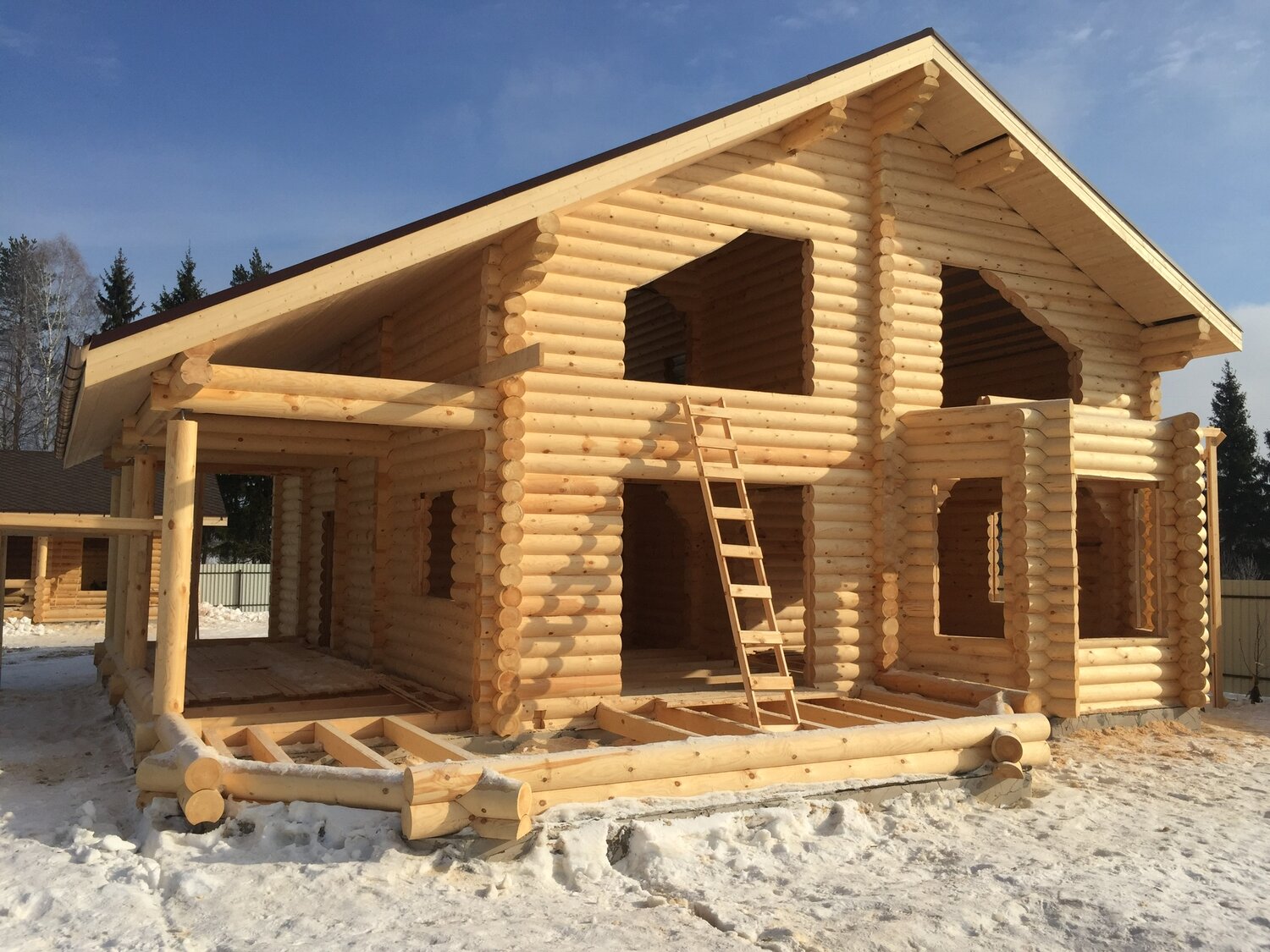 Незавершенный бревенчатый дом (сруб) из оцилиндрованного бревна на участке в Севастополе: уложены нижние венцы, видна чаша соединения