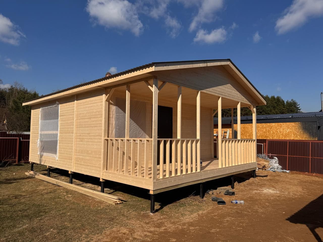 Собранная коробка каркасно-щитового дома из готовых заводских панелей: установлены стены и кровля, готовится монтаж окон и отделки