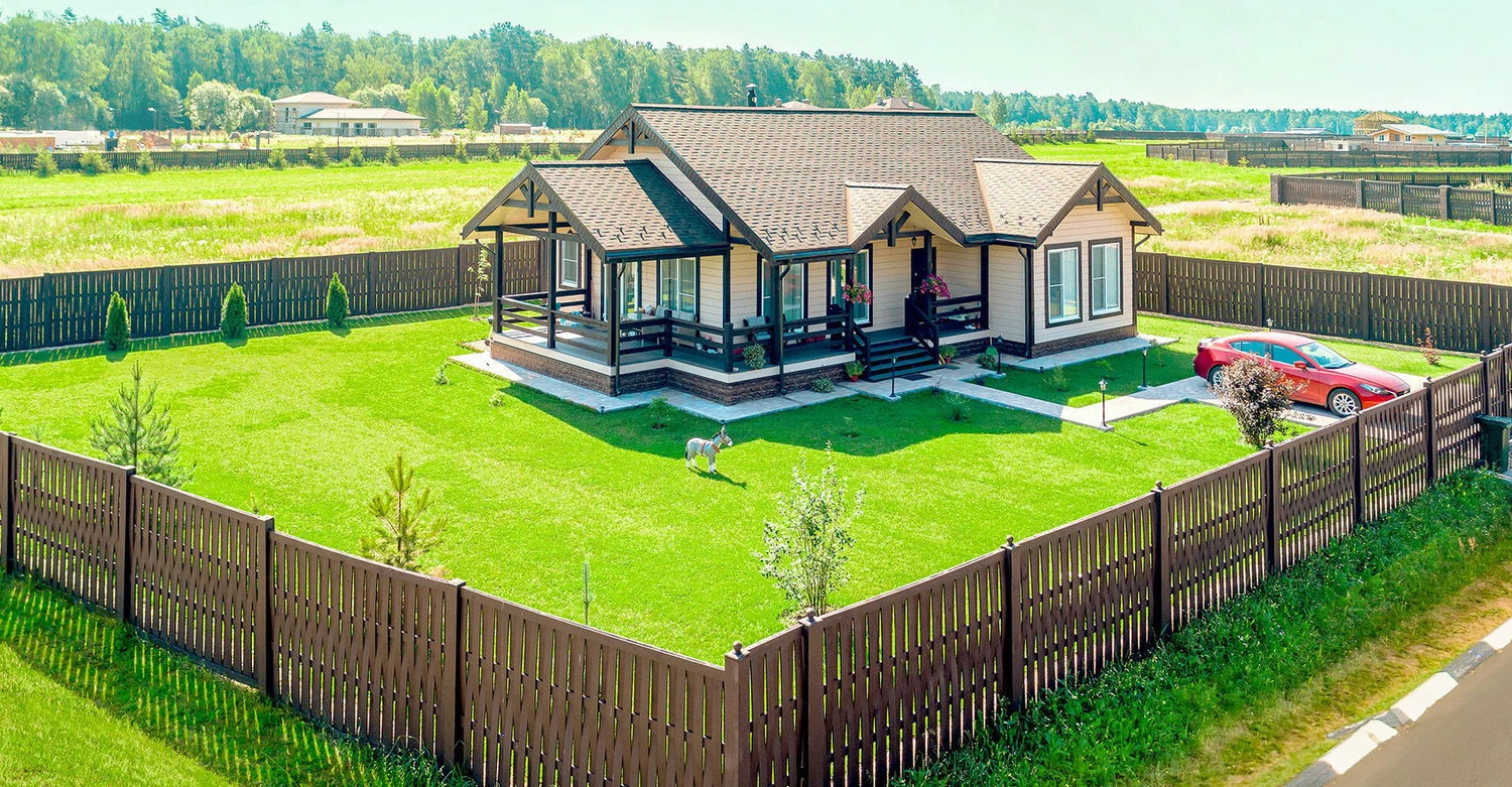 Частный дом, построенный на зеленом поле за пределами населенного пункта — пример полевого участка ЛПХ