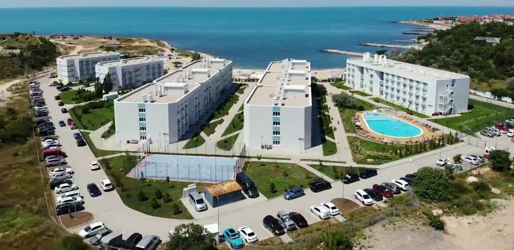 Вид сверху на современный апарт-отельный комплекс «Античная Лагуна» с бассейнами и благоустроенной территорией в Камышовой бухте (Севастополь).