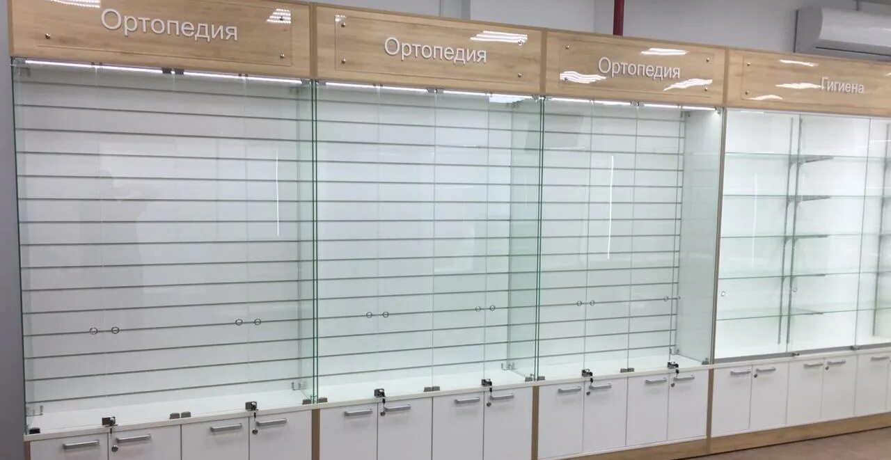 Фото пустого торгового стеллажа со стеклянной витриной и запирающимися тумбами — готовое оборудование для размещения товара в арендованной зоне магазина